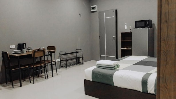 A modern bedroom with a bed, a desk, chairs, and a wardrobe. - The One Rooms (Tambon Rawai)