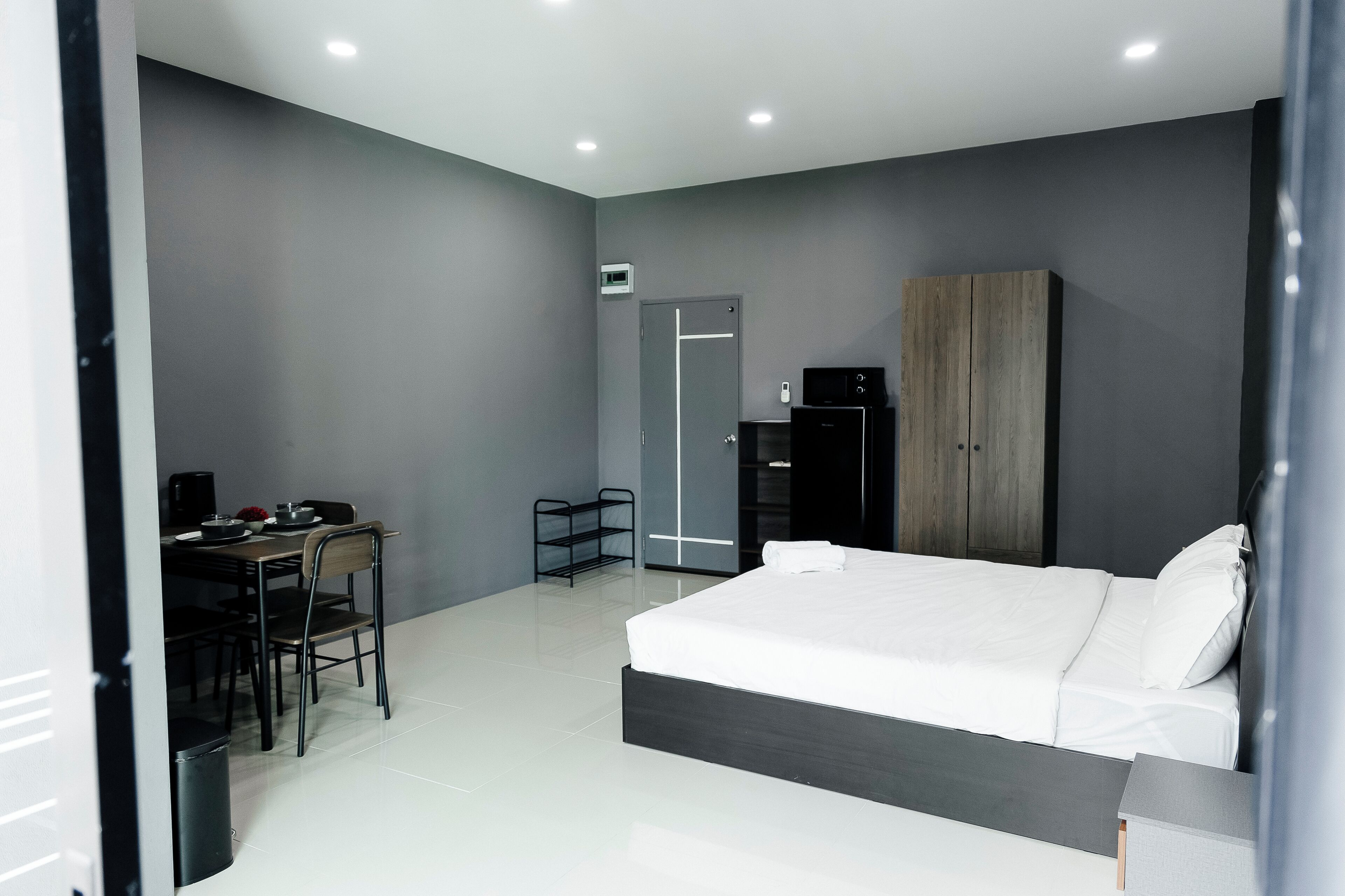 Quarto moderno com uma cama grande, uma escrivaninha e um guarda-roupa.