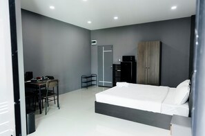 Quarto moderno com uma cama grande, uma escrivaninha e um guarda-roupa.