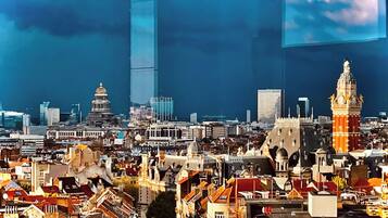 A cityscape with a prominent clock tower and modern buildings.