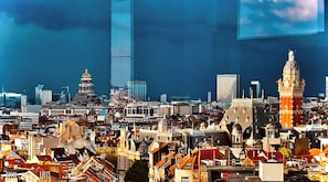 A cityscape with a prominent clock tower and modern buildings.