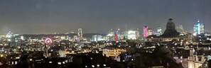 A nighttime cityscape with illuminated buildings and a prominent dome structure.
