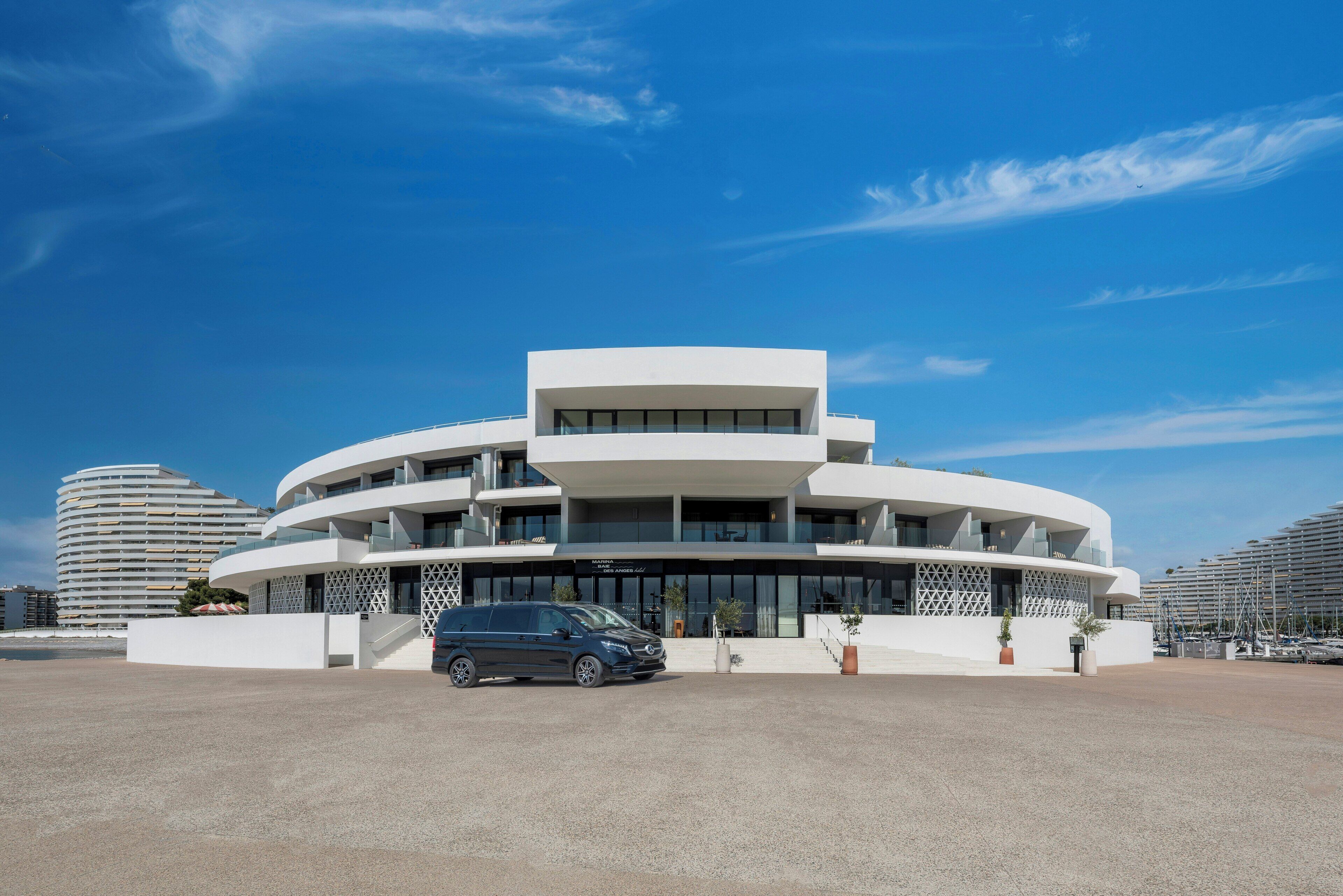 Un edificio moderno con diseño circular, que presenta varios balcones y amplias ventanas.
