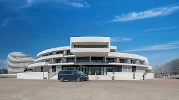 Un edificio moderno con diseño circular, que presenta varios balcones y amplias ventanas.