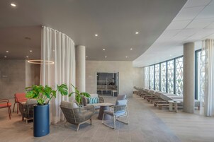 Un vestíbulo amplio con zonas de estar, ventanas grandes y un diseño moderno.