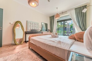 Ein Schlafzimmer mit Bett, Schreibtisch, Spiegel und Blick ins Freie.
