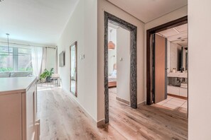 A modern interior with a kitchen, dining area, and a bathroom visible through an open doorway. - HAVN - Spacious One Bedroom in Downtown Dubai (Dubai)