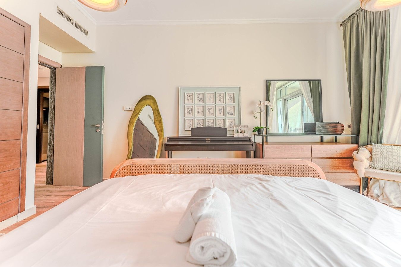 Ein Hotelzimmer mit einem Bett, einem Schreibtisch, einem Spiegel und einem Fenster mit Vorhängen.