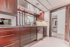 A modern kitchen with a microwave, sink, and dishwasher. - HAVN - Spacious One Bedroom in Downtown Dubai (Dubai)