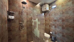 A bathroom with a glass-enclosed shower, a toilet, and a wall-mounted soap dispenser. - Villa Exquise (Legian)