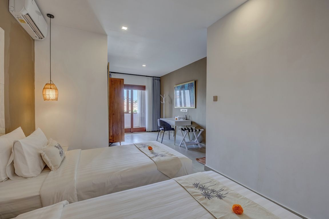 Una habitación de hotel con dos camas, un escritorio y una silla.