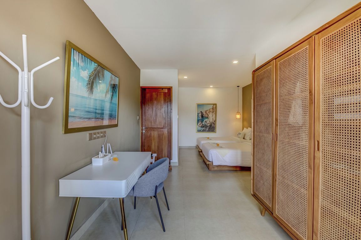 Habitación de hotel con zona de comedor, cama y un amplio panel de madera.