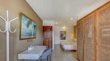 Habitación de hotel con zona de comedor, cama y un amplio panel de madera.