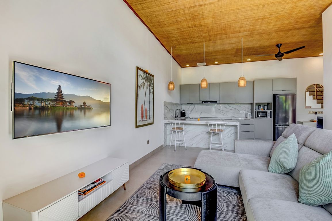 Una sala de estar moderna con un sofá, una mesa de centro y obras de arte en la pared.