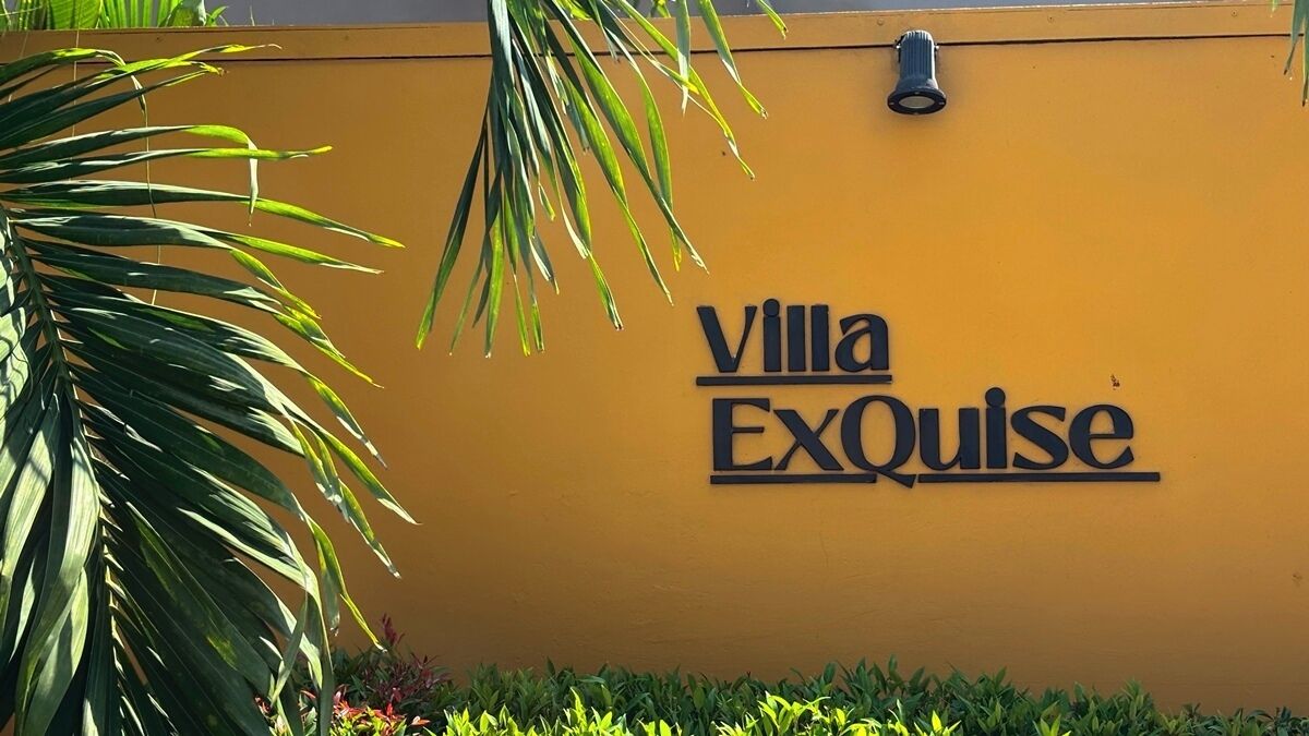 A yellow wall with the text 'Villa ExQuise' indicating the name of the property.