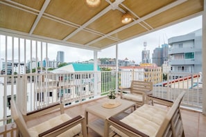 A balcony with a view of a cityscape, including buildings and a bridge.