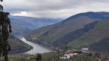 Un río serpentea a través de campos en terrazas con un pequeño asentamiento y algunos edificios a lo largo de la orilla.