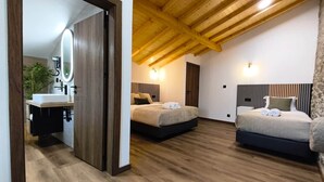 A modern bedroom with two beds, a wooden ceiling, and a bathroom with a sink and mirror. - Castas D'ouro Guest House II (Casal de Loivos)