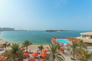 A resort with a pool, beach, and ocean view. - Luxury 1-bedroom apartment with direct beach access (DUBAI)