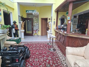 A hotel lobby with a reception desk, a dining area, a chandelier, and a toy car. - Vrbo Property (Wanzleben-Börde)