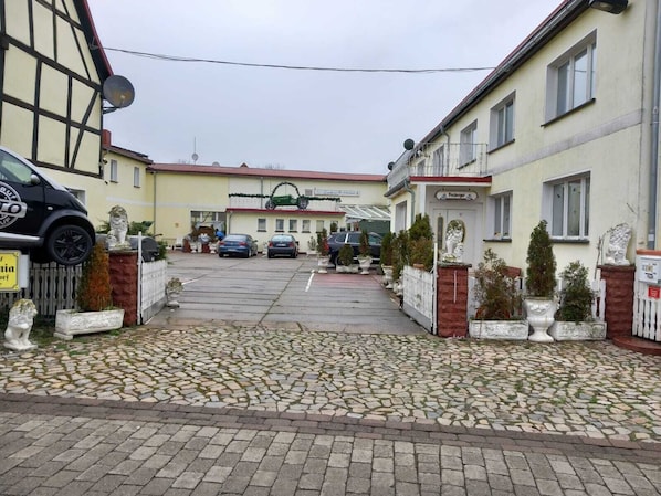 A street view with a row of two-story buildings, a paved road, and parked cars. - Vrbo Property (Wanzleben-Börde)