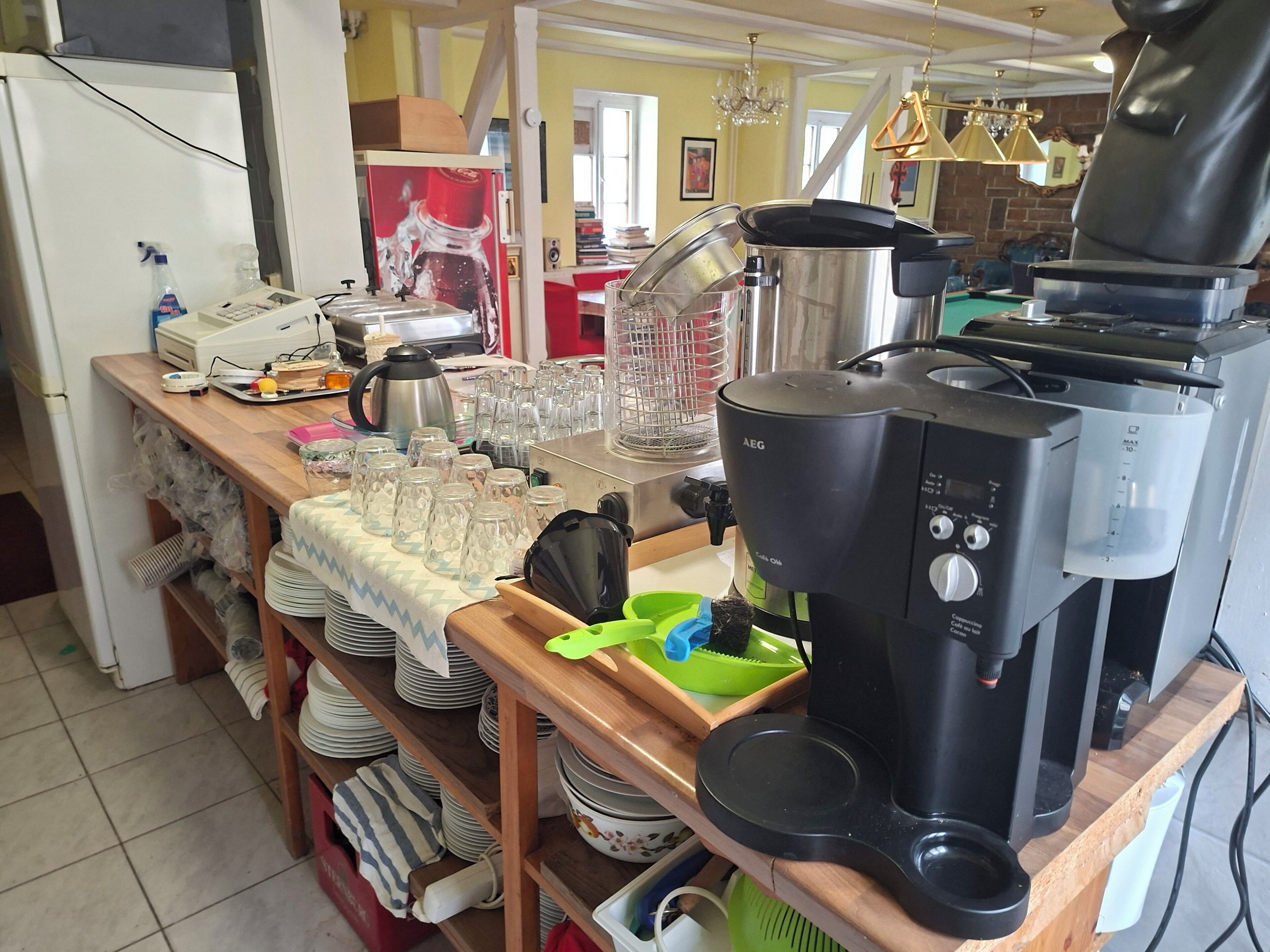 A kitchen with a coffee maker, a kettle, and various kitchen utensils.