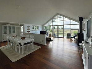 Una cocina amplia con comedor, ventanas grandes y un estufa de leña.