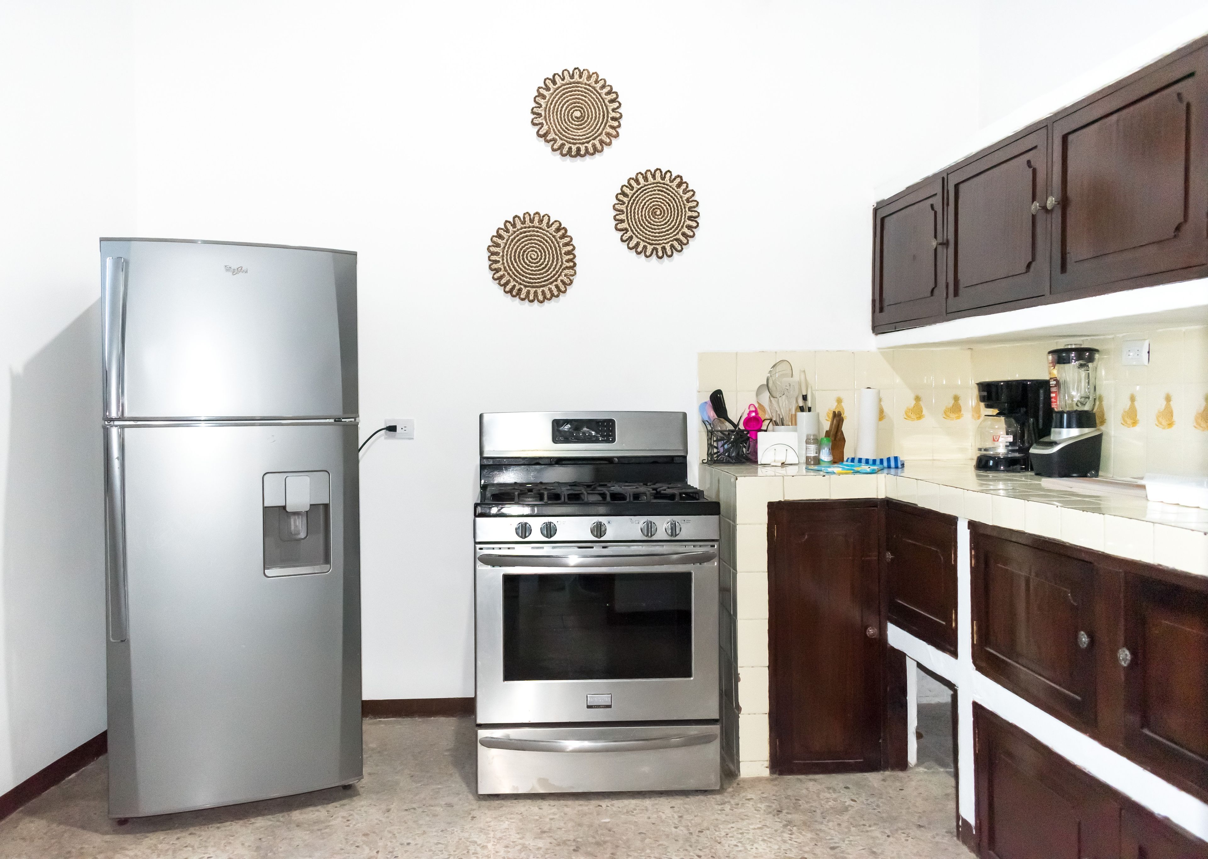Una cocina con refrigerador, estufa y armarios de madera.