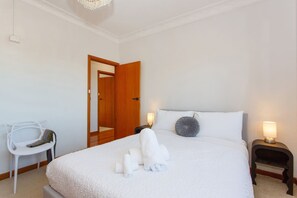 A hotel room with a bed, a chair, a nightstand, and a door. - Sandcastle Loft - The Ultimate Fremantle Escape (Fremantle)