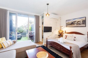 A hotel room with a bed, a sofa, a dining area, and a large window. - The Lab - Heart of North Fremantle (North Fremantle)