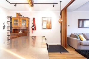 A modern kitchen with a wooden cabinet, a glass-top table, and a red towel hanging on the wall. - The Lab - Heart of North Fremantle (North Fremantle)