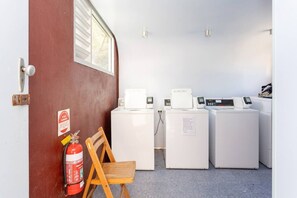 A laundry room with two washing machines, a fire extinguisher, and a wooden chair. - The Lab - Heart of North Fremantle (North Fremantle)