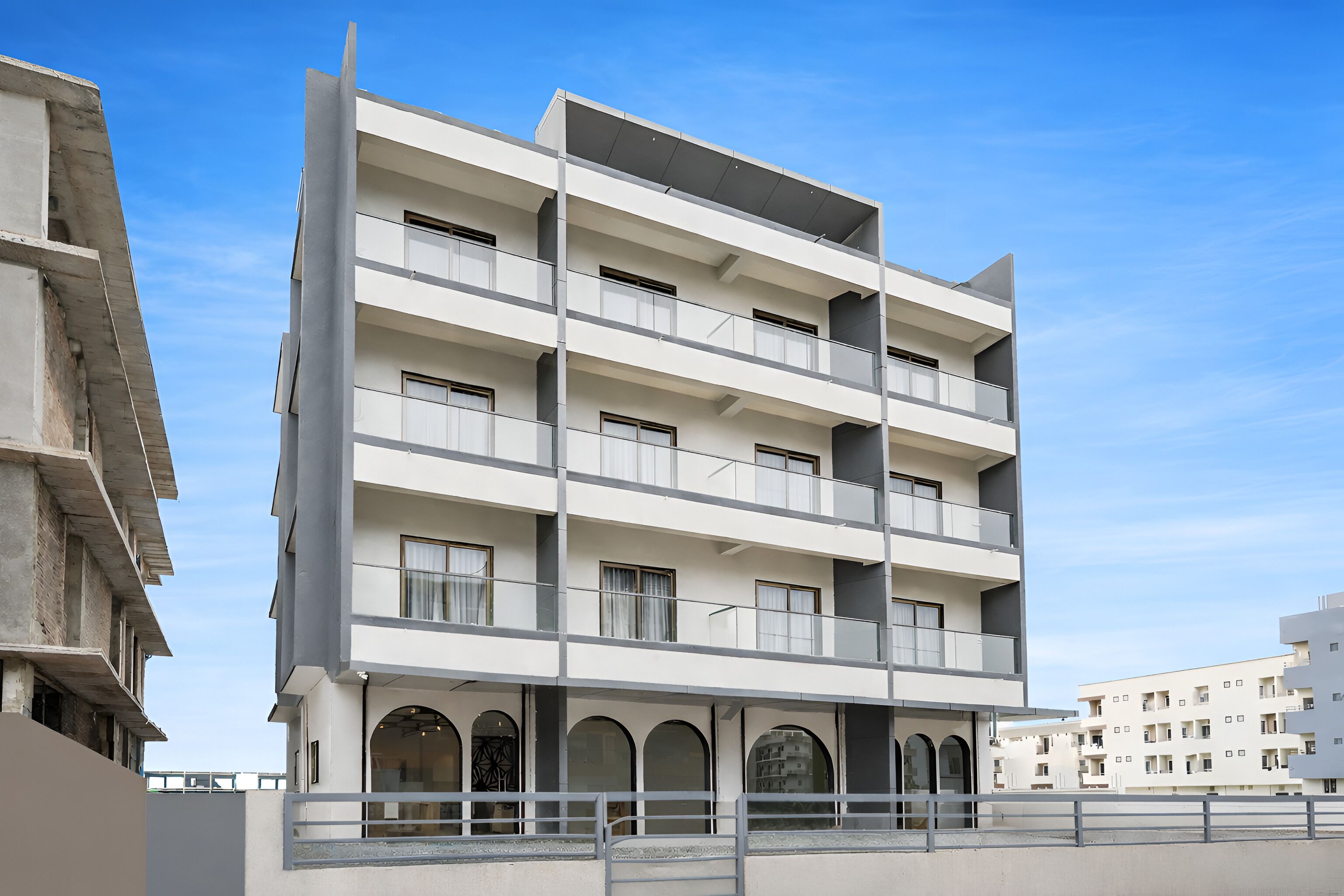 Un edificio a più piani con balconi, ampie finestre e facciata piatta.