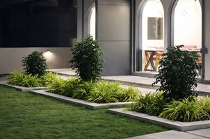 A landscaped garden with rectangular planters and a well-maintained lawn.