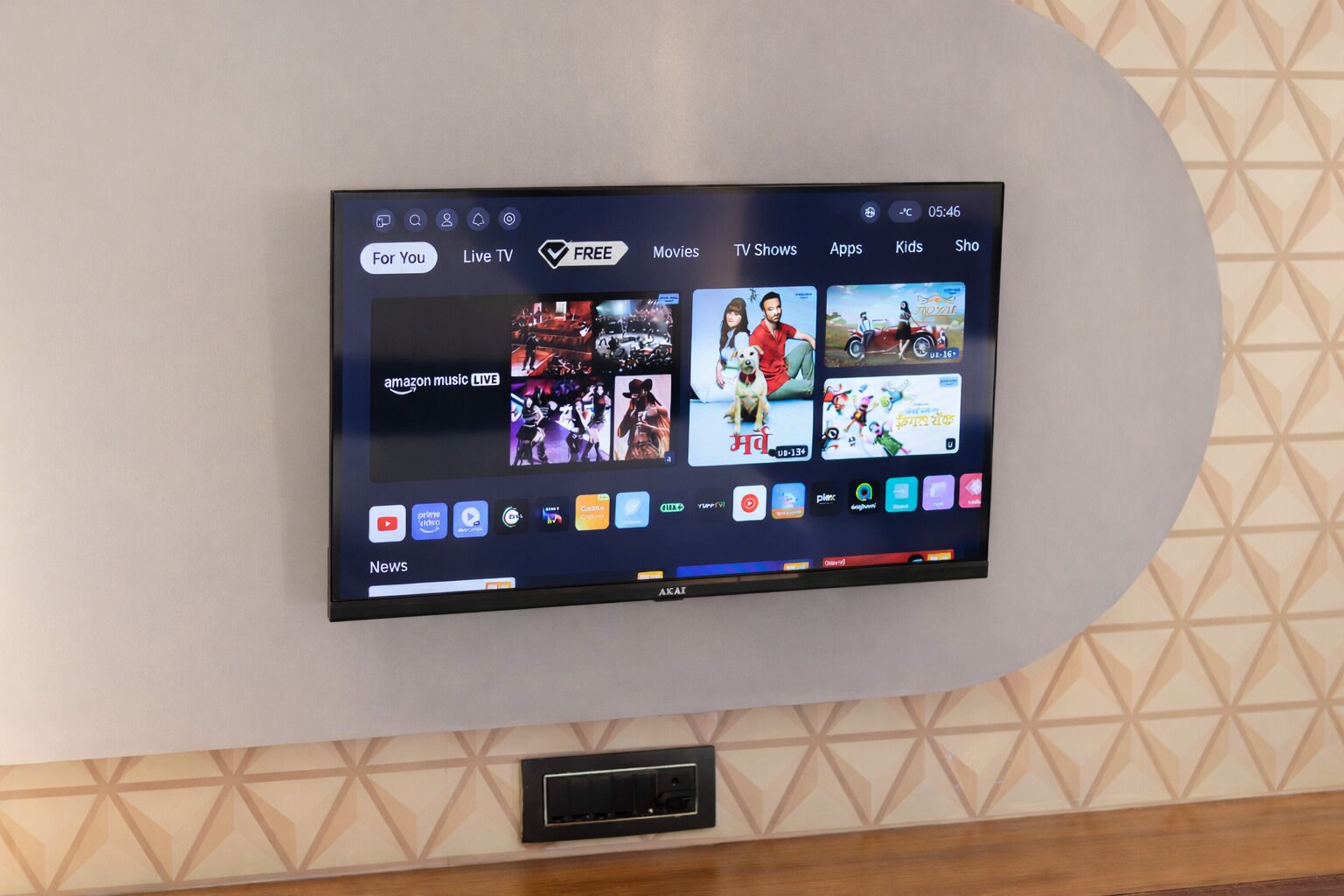 A flat-screen TV mounted on a wall with a geometric pattern.