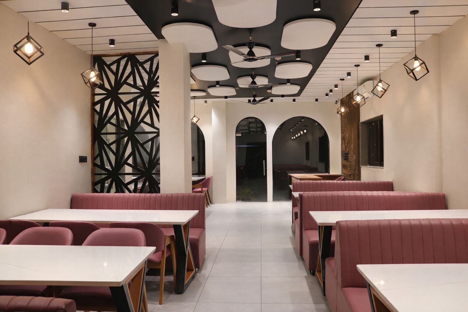 Interno di un ristorante con banconi, tavoli e lampadari a sospensione.