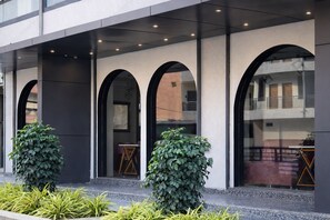 A building with a modern architectural design, featuring arched windows and a balcony.