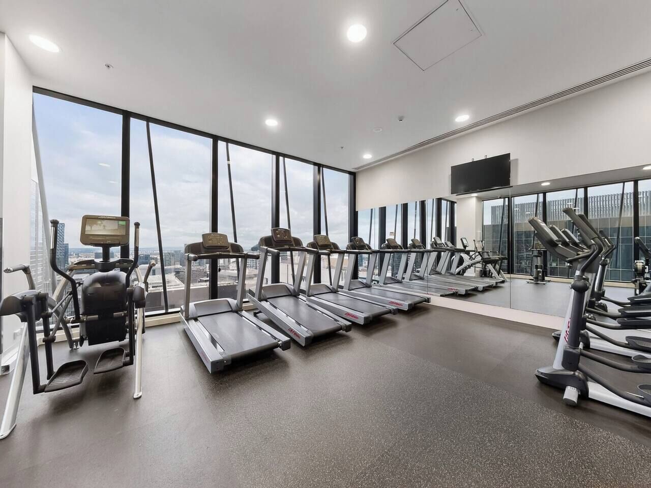 Una palestra con tapis roulant, cyclette e vogatore.