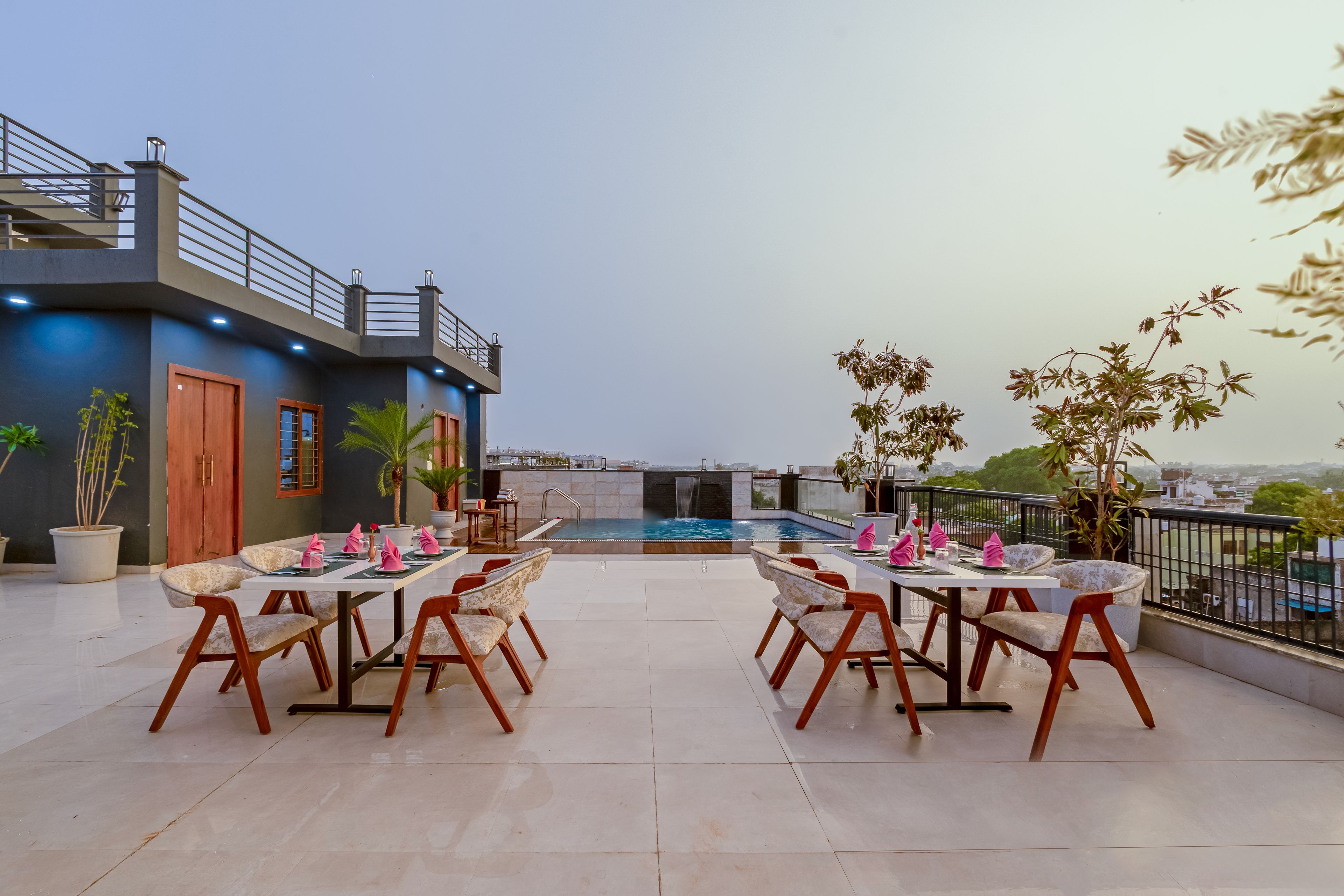 Una terrazza sul tetto con piscina, zona pranzo e vista sulla città.