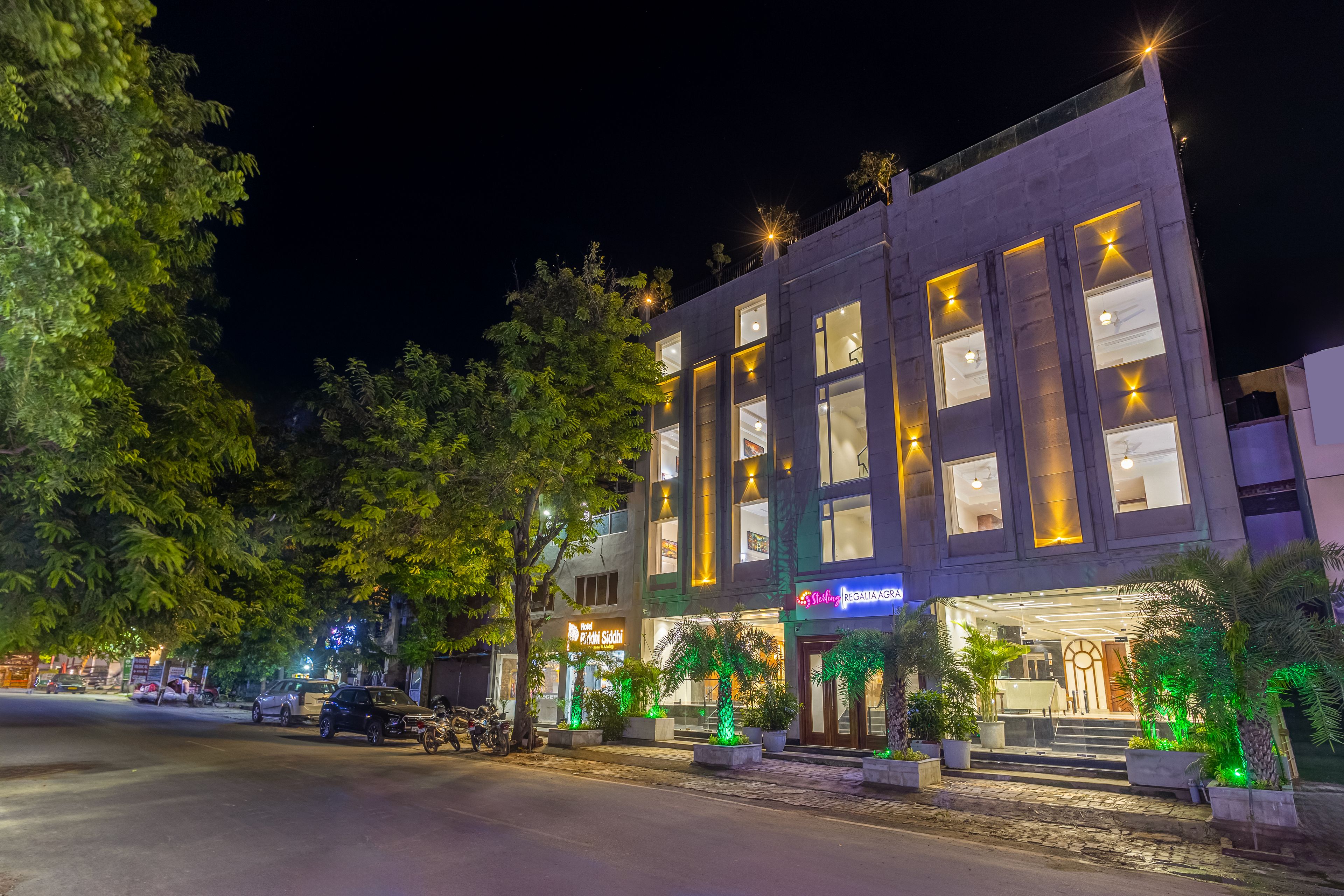 A multi-story hotel with illuminated signage, a visible restaurant, and a well-lit entrance.