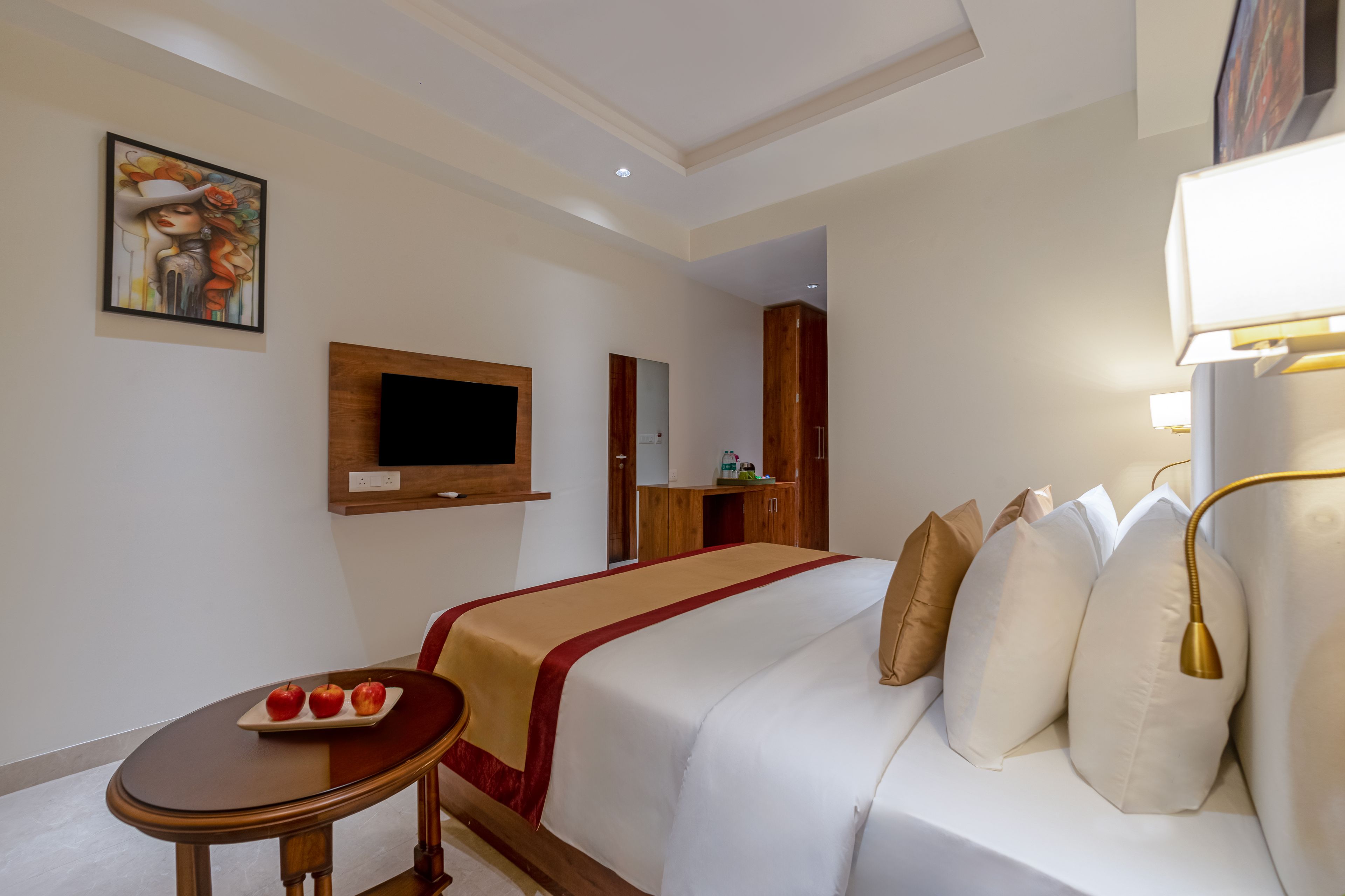 Ein Hotelzimmer mit Bett, Nachttisch und an der Wand befestigtem Fernseher.