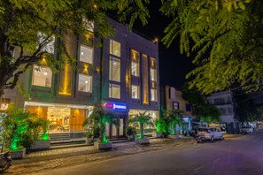 A building with a restaurant named 'Sterling' on the ground floor, featuring outdoor seating with potted plants. - Sterling Regalia Agra (Agra)