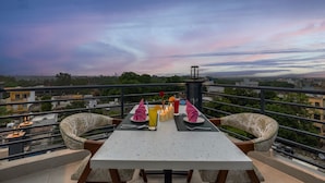 A dining table with chairs and a view of the cityscape.
