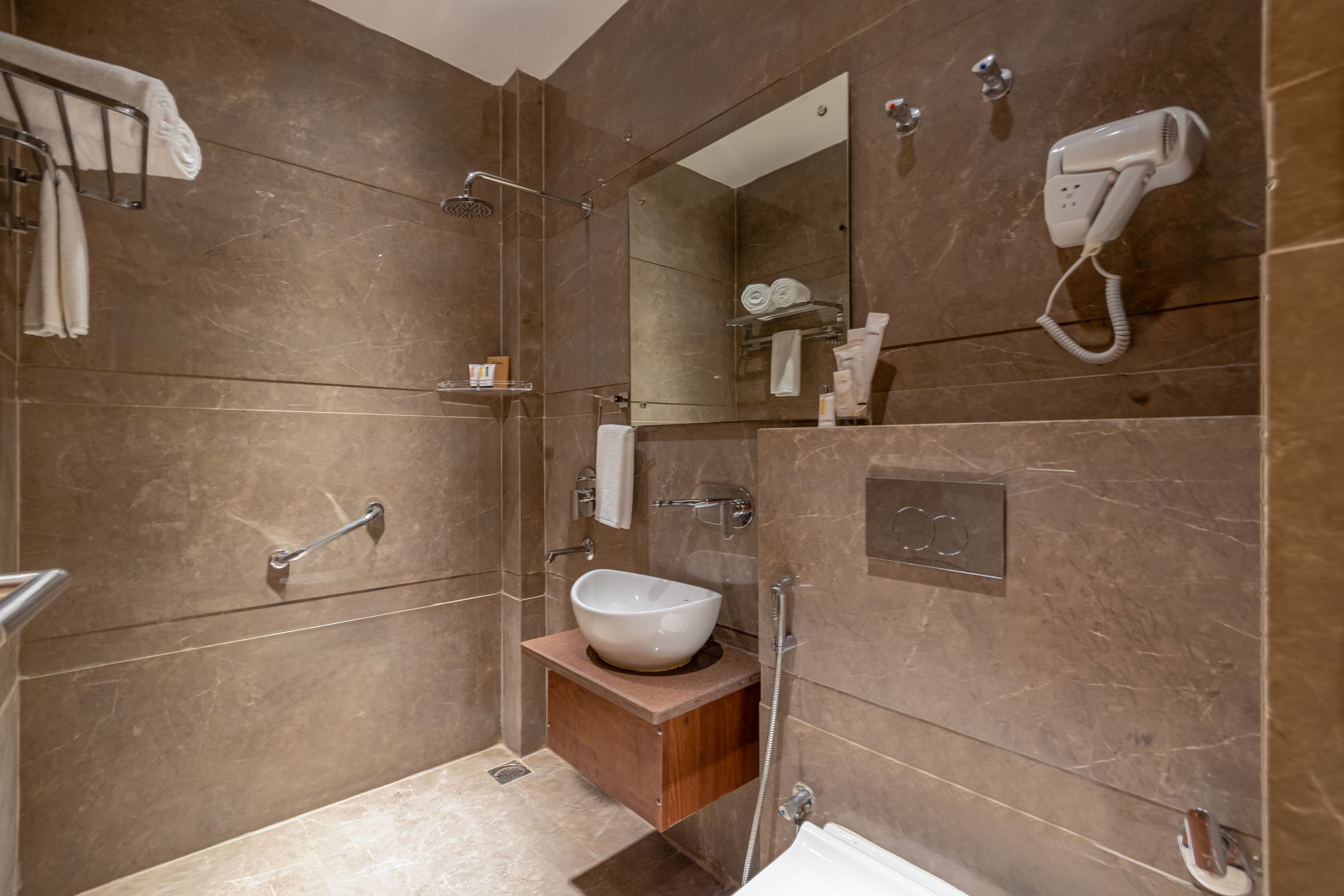 A modern bathroom with a large mirror, a white sink, and a shower area.