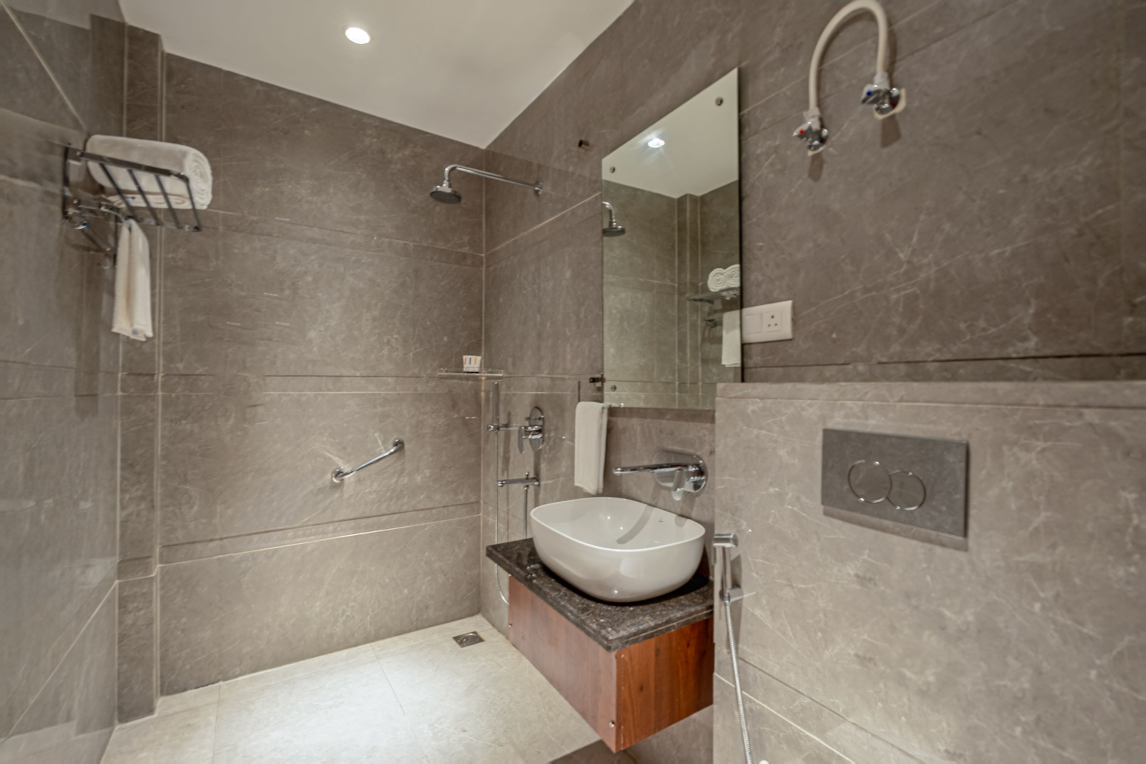 Un baño moderno con un espejo grande, un lavabo empotrado y una zona de ducha.