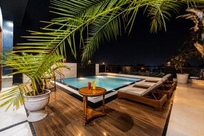 A rooftop pool area with a hot tub, lounge chairs, and potted plants. - Sterling Regalia Agra (Agra)