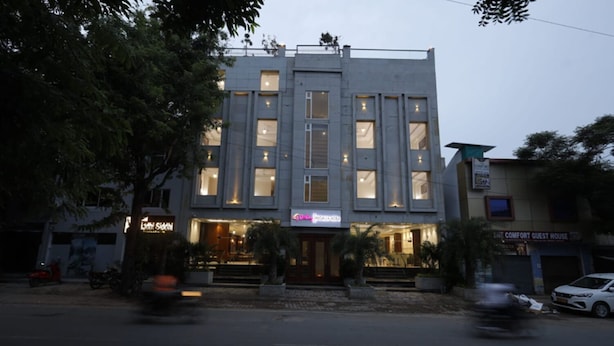 A multi-story building with a flat facade, large windows, and a sign for 'The Comfort Guest House'. - Sterling Regalia Agra (Agra)