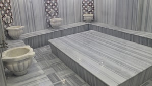 A public restroom with multiple urinals and a large bathtub area. - GRAND ALİN HOTEL (Turhal)