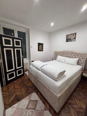 A bedroom with a bed, a door, a window, and a painting on the wall. - Square 29,Stari grad
two minutes to Skadarlija (Beograd)