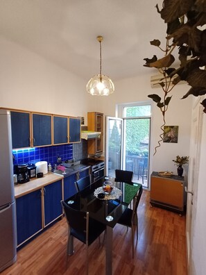 A compact kitchen with blue cabinets, a dining table with chairs, and a hanging light fixture. - Square 29,Stari grad
two minutes to Skadarlija (Beograd)